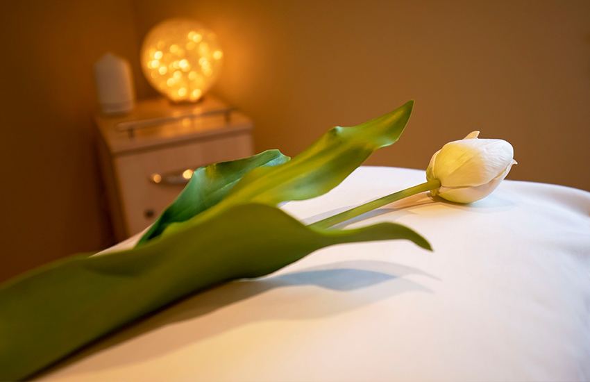 A white tulip on a treatment bed at Aspen Spa