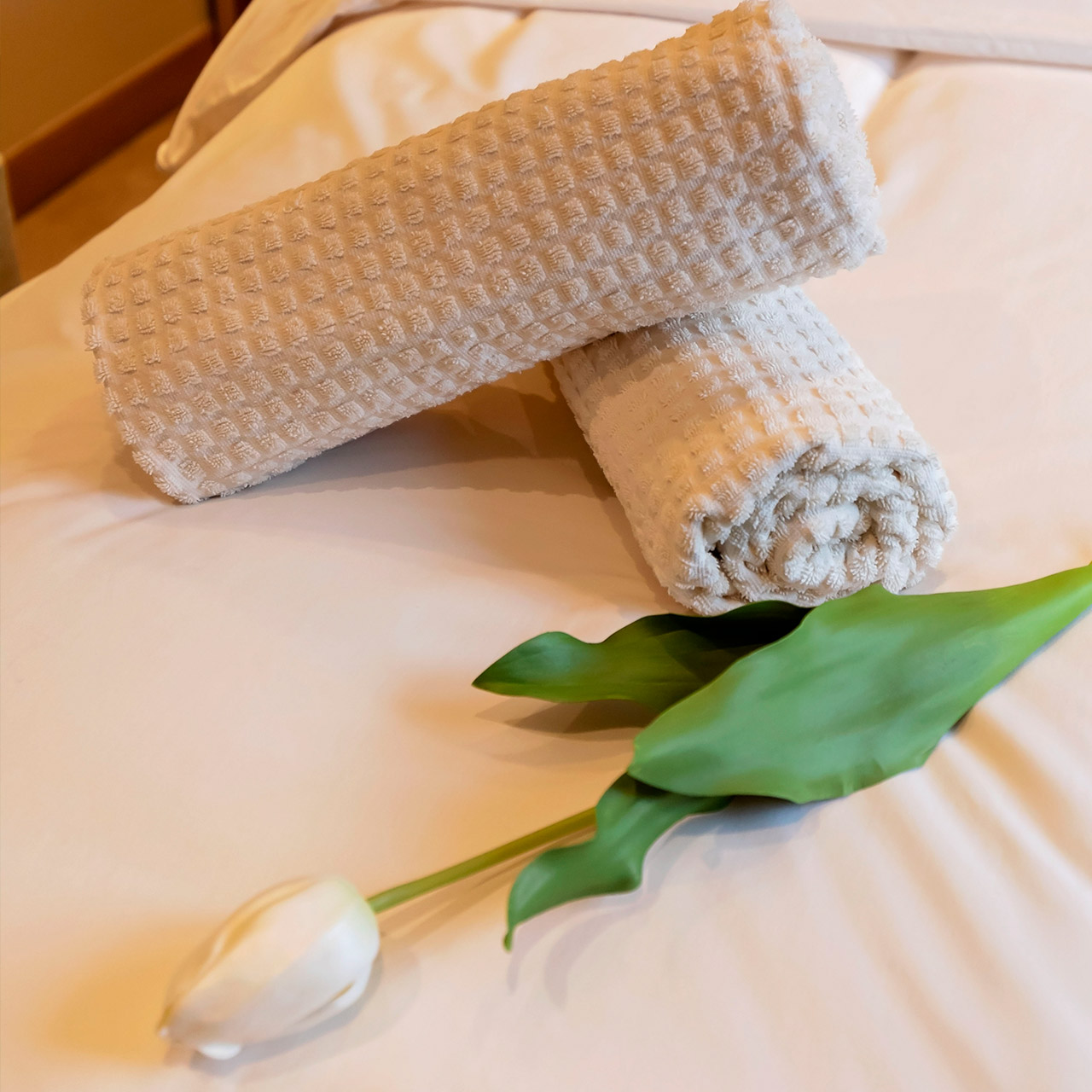 A white tulip and towels on the treatment bed at Aspen Spa